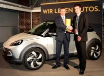 Andreas Marx, Director de Marketing de Opel Alemania (a la derecha) y Timm Sandmeyer, Director del Jurado de los Premios 'Plus X Award” posan con el galardón otorgado a Opel delante del concepto de Mini Crossover urbano de 3 puertas ADAM ROCKS.