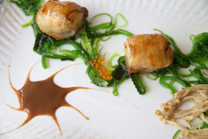 Vieras envueltas en panceta ibérica con alga wakame y salsa de tamarindo.