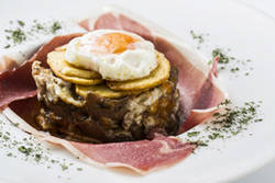 Huevos rotos con setas y jamón.