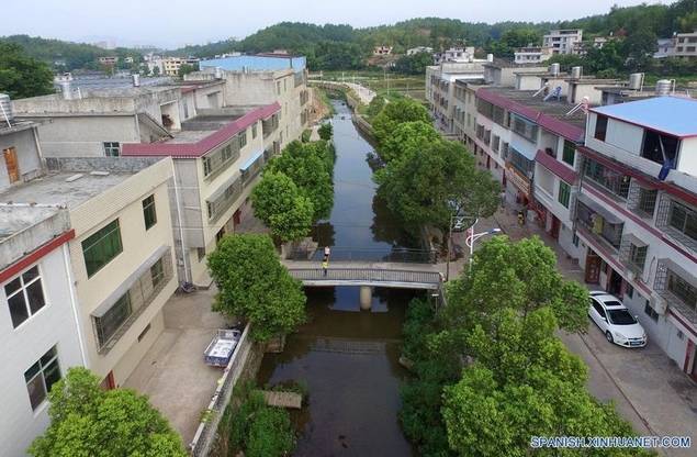 Imagen de 28 de julio de 2017, de la vista de la aldea Gufang en la municipalidad de Wenwuba del condado de Huichang, Ciudad de Ganzhou, en la provincia de Jiangxi, en el este de China. Desde 2016, el gobierno local en la aldea de Gufang tomó medidas dirigidas a la reducción de la pobreza. La infraestructura, como caminos, casas y lámparas de energía solar, fueron construidas y nuevas industrias fueron introducidas en la aldea, lo cual la cambió drásticamente. Estanques de peces, invernaderos, así como huertas, aumentaron la economía agrícola local. Un ambiente mejorado en la aldea también atrajo muchos trabajadores migrantes para regresar por los negocios de agricultura y turismo. (Xinhua/Peng Zhaozhi).
