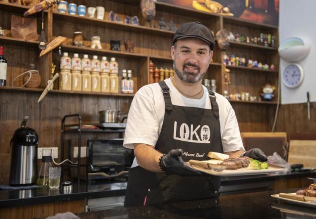 Foto del 20 de junio de 2024 de Gabriel Martín, empresario de Uruguay, muestrael filete que acaba de cocinar en su restaurante LOKO, en la ciudad de Wuhu, la provincia de Anhui, en el este de China. (Xinhua/Fu Tian)