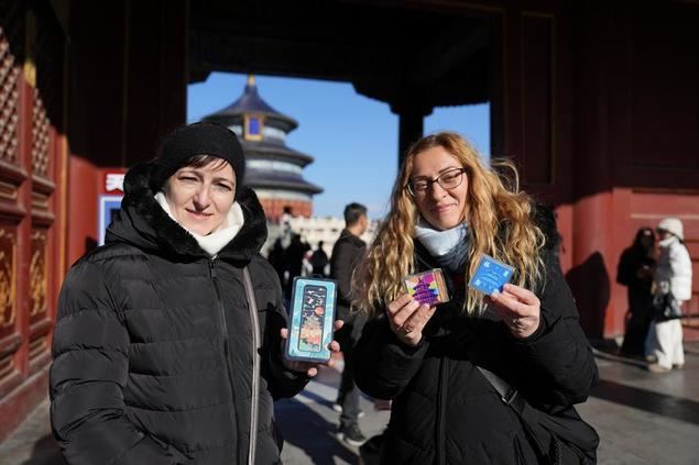 Turistas de Hungría muestran recuerdos comprados en el parque Tiantan (Templo del Cielo) en Beijing, la capital de China, el 5 de diciembre de 2024. (Xinhua/Ju Huanzong)