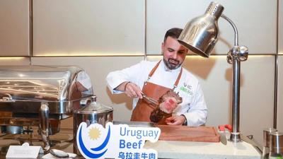 Gabriel Martín prepara filetes para una delegación uruguaya de visita en Beijing, capital de China, el 22 de noviembre de 2023. (Xinhua)