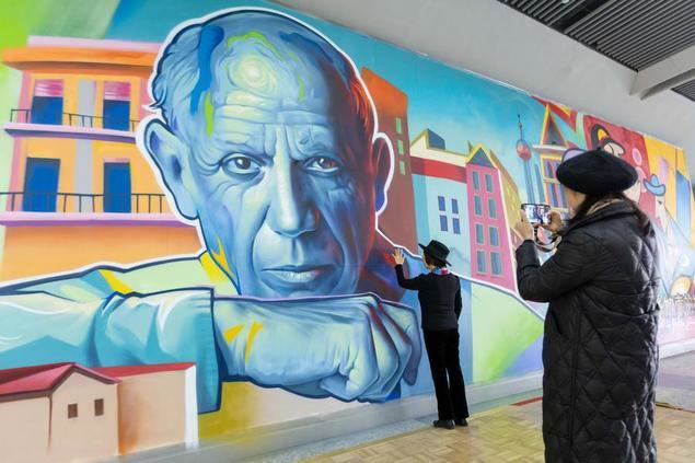 Pasajeros toman fotos a un retrato de Pablo Picasso que hace parte de un mural en la estación de metro Longyang Road, en Shanghai,este de China, el 7 de diciembre de 2023. (Xinhua/Wang Xiang)