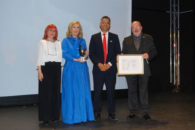 Nieves Herrero recoge el premio de manos de Hermel Balcázar, junto a los conductores del acto de entrega, los periodistas Garrido y José Luis Barceló.