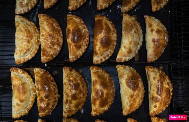 Imagen del 7 de abril de 2023 de empanadas recién horneadas en el local 'La tiendita al corte', en el marco del Día Mundial de la Empanada, en la ciudad de Buenos Aires, capital de Argentina. Los argentinos se alistan para celebrar este sábado el Día Mundial de la Empanada, una delicia en forma de masa rellena que llegó con la inmigración europea durante el siglo XIX y que se consume en todos los rincones del país, sin distinción de clases sociales, lo que le ha valido su denominación de 'Patrimonio Cultural, Alimentario y Gastronómico Argentino'. (Xinhua/Martín Zabala)