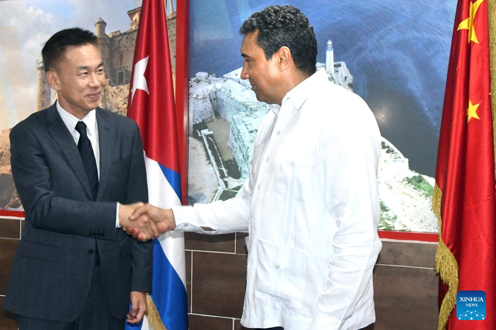 Imagen del 25 de junio de 2025 del embajador chino en Cuba, Hua Xin (i), estrechando la mano del ministro de Transporte cubano, Eduardo Rodríguez (d), después de la llegada de un avión procedente de Beijing, capital de China, de la aerolínea Air China, en La Habana, capital de Cuba. La aerolínea Air China comenzó a llevar carga comercial a Cuba, como parte de un programa que profundiza las relaciones entre los dos países, próximas a cumplir 65 años de establecimiento de lazos diplomáticos. (Xinhua/Joaquín Hernández)