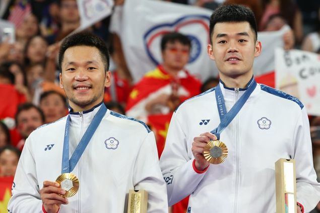 Los atletas olímpicos de Taiwán Lee Yang (izquierda) y Wang Chi-lin muestran con orgullo sus medallas de oro en dobles masculino de bádminton el 4 de agosto en París. (Foto de CNA)